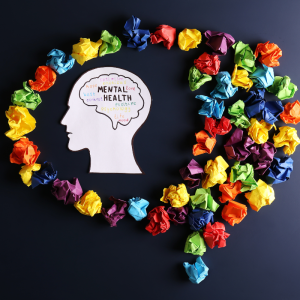 Image of head with the words mental health at the center surrounded by crumpled up papers.