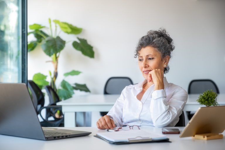 Mature woman looking at a computer in her office.