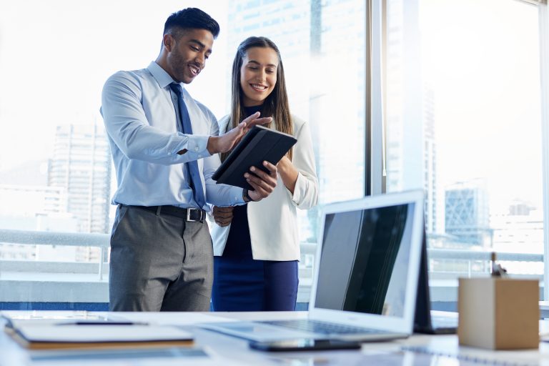 Shot of two businesspeople discussing something on a digital tablet.