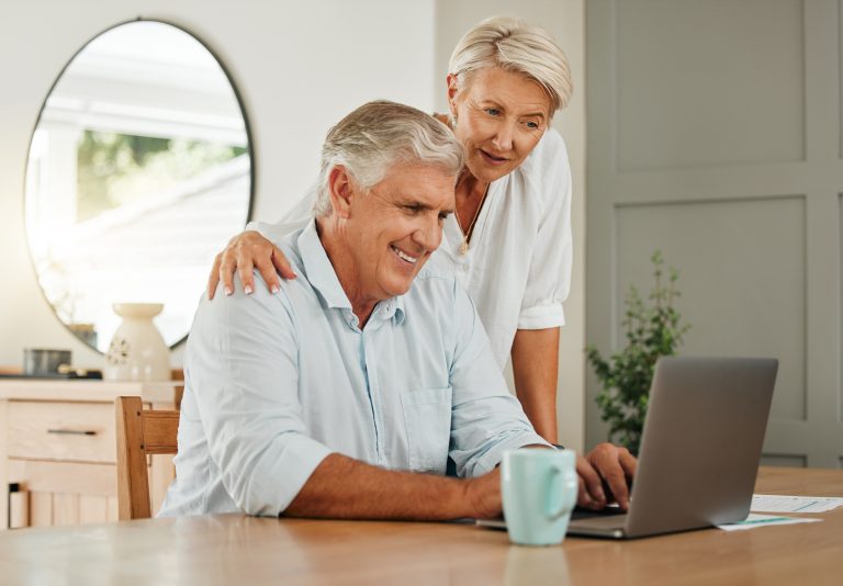 Retired couple looking at laptop together.