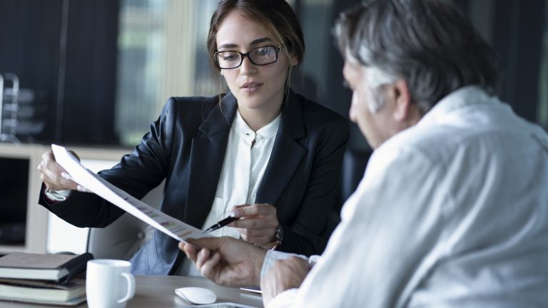 Two business people looking at a document.